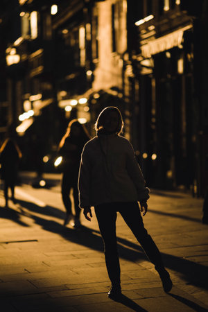 A woman on the street in the backlight during a golden sunset.の写真素材