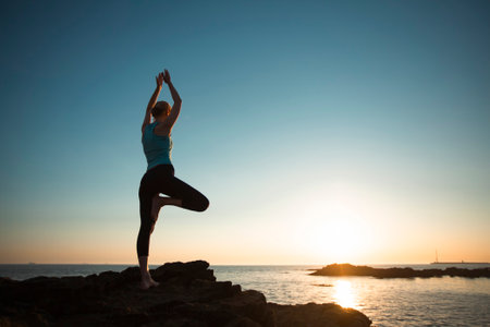Yoga women silhouette on the Atlantic shore during an amazing sunset.の写真素材