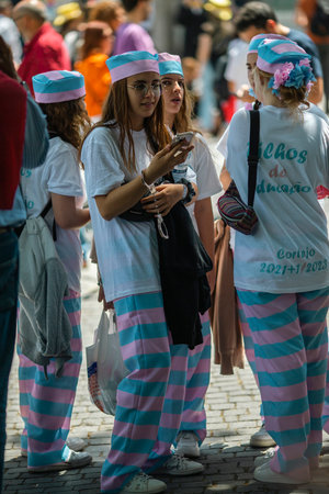 PORTO, PORTUGAL - MAY 9, 2023: Porto's Queima das Fitas Parade - annual festivity of Portuguese students of universities. The graduates wear a top-hat and a walking-cane, both colors of their Faculty.のeditorial素材