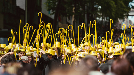 PORTO, PORTUGAL - MAY 9, 2023: Porto's Queima das Fitas Parade - annual festivity of Portuguese students of universities. The graduates wear a top-hat and a walking-cane, both colors of their Faculty.のeditorial素材
