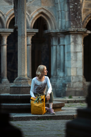 A woman traveler sits on the steps to an ancient fortress.の写真素材