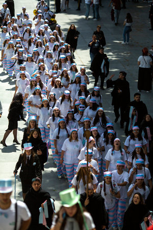 PORTO, PORTUGAL - MAY 9, 2023: Porto's Queima das Fitas Parade - annual festivity of Portuguese students of universities. The graduates wear a top-hat and a walking-cane, both colour of their Faculty.のeditorial素材