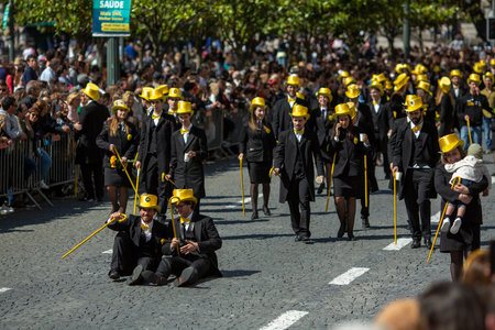 PORTO, PORTUGAL - MAY 9, 2023: Porto's Queima das Fitas Parade - annual festivity of Portuguese students of universities. The graduates wear a top-hat and a walking-cane, both colour of their Faculty.のeditorial素材