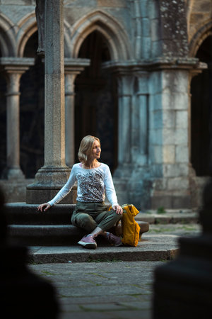 A female traveler sits resting in an ancient fortress.の写真素材