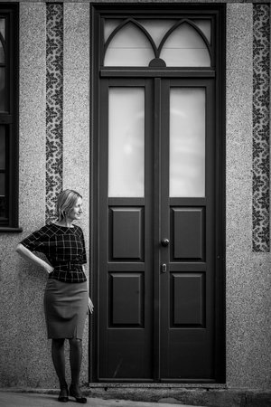 A woman stands outside the front a house in Porto, Portugal. Black and white photo.の写真素材