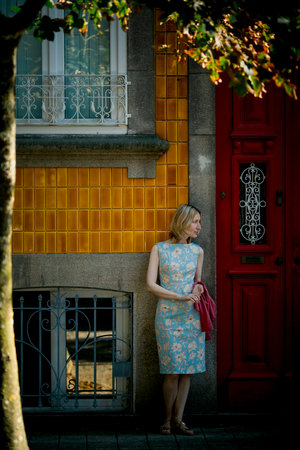 A woman stands near the door of a traditional town house in Porto, Portugal.の写真素材