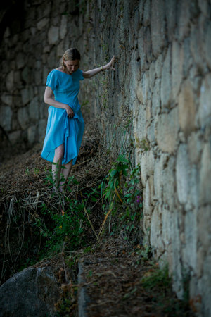 A woman dressed in blue makes her way through ancient ruins.の写真素材