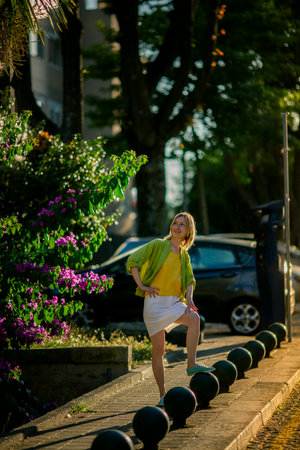 A woman on a city street at sunset.の写真素材