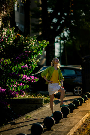 A woman poses on a city street during sunset.の写真素材
