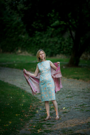 Woman in summer dress with shawl in city park.の写真素材