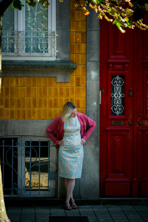 A woman stands in front of a traditional town house in Porto, Portugal.の写真素材