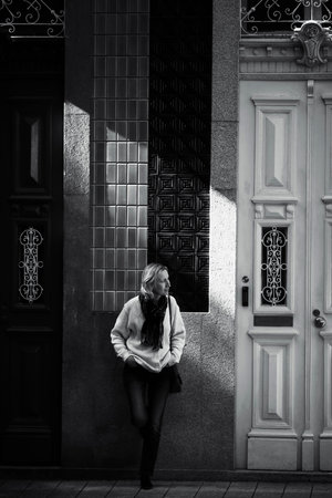 A woman stands on a street in Porto, Portugal, outside a traditional building. Black and white photo.の写真素材