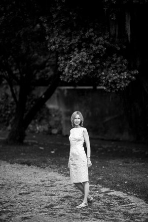 Full-length portrait of a woman standing on a path in a park. Black and white photo.の写真素材