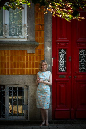 A woman stands outside a traditional Portuguese house in Porto.の写真素材