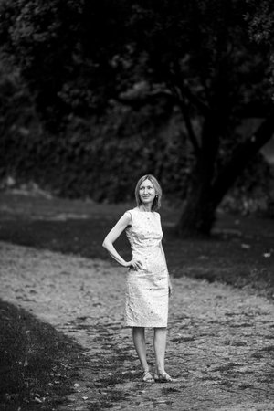 A woman stands on a park path. Black and white photo.の写真素材