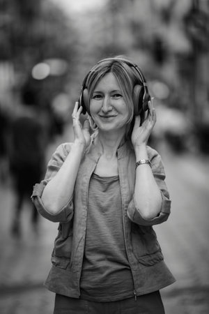 Portrait of a woman enjoying music on headphones. Black and white photo.の写真素材