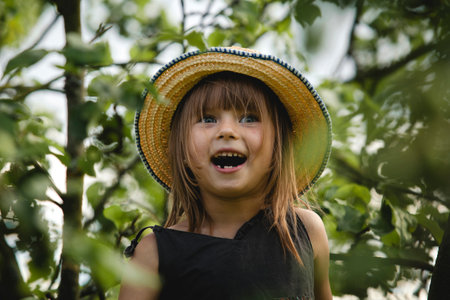 Portrait of a sweet little surprised girl in a garden.の写真素材