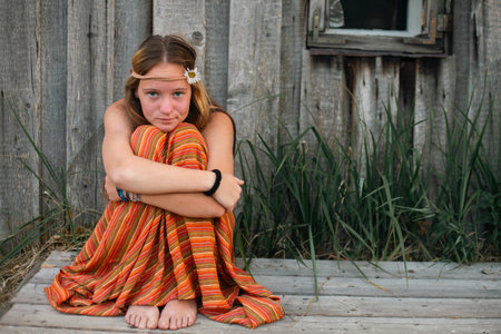 A country girl sits on the ground with a guilty look.の写真素材