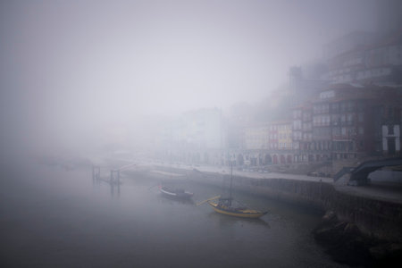 View of the Ribeira waterfront in thick fog, Porto, Portugal.