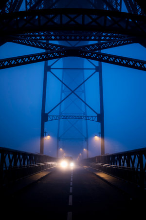 View or the Dom Luis I Bridge at night in fog, Porto, Portugal.