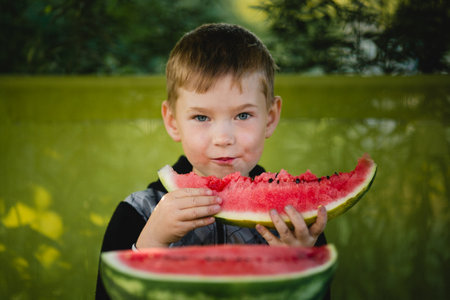 A little boy eats a watermelon.