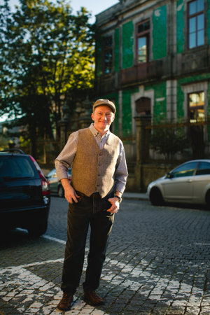 A middle-aged man wearing a vest and cap, standing outdoors, exuding a relaxed and confident demeanor.の写真素材