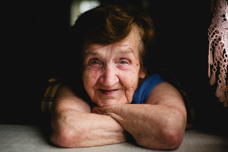 Close-up portrait of an elderly solitary woman, her face adorned with a gentle smile, evoking warmth...