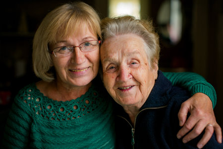 Portrait of a mature woman embracing her elderly mother.
