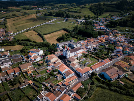 Top-down view of Maia, a scenic coastal village in Ribeira Grande, Azores, with rolling green hills...