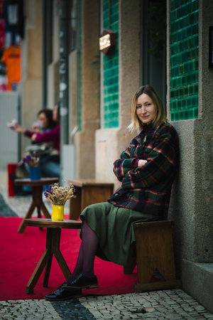 A woman sits in an open-air café, radiating a warm pre-Christmas mood.の写真素材