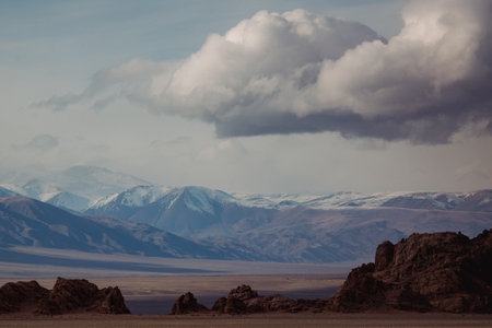 The foothills of Mongolia stretch beneath a heavy, leaden sky. The landscape feels raw and unforgiving, shaped by wind, stone, and silence - vast, ancient, and unyielding.の写真素材