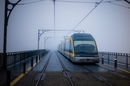 Porto Metro crossing Dom Luis I Bridge in dense fog above the Douro River.