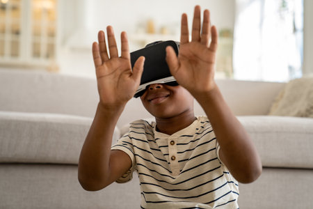 Small curious African American child boy wearing VR goggles spending time in virtual worldの写真素材