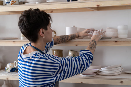 Successful ceramics studio owner arranges a showcase with finished products for saleの写真素材