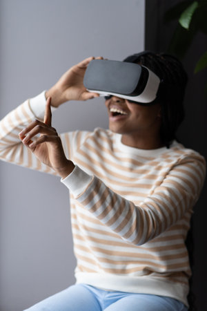 Casual girl in vr glasses touch interactive screen use virtual reality goggles for entertainmentの写真素材