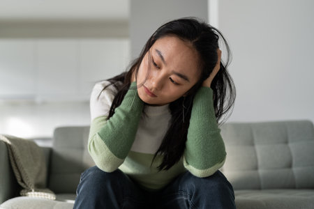 Unhappy depressed young Asian woman feeling sad and lonely after breakup or divorceの写真素材