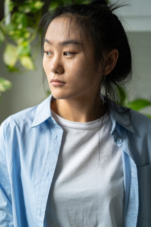 Portrait of unhappy sad young Asian woman at homeの写真素材