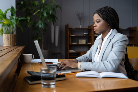 Serious frowning ceo businesswoman at desk look at laptop screen read email from partner concerned