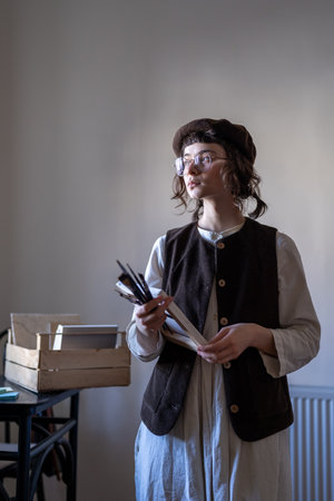 Thoughtful creative girl artist look to window holds brushes canvas in hands think ideas for picture