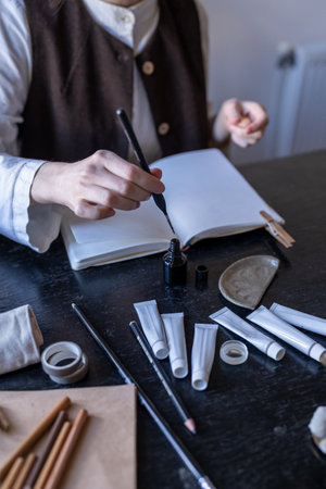 Female artist painting with ink in sketchbook