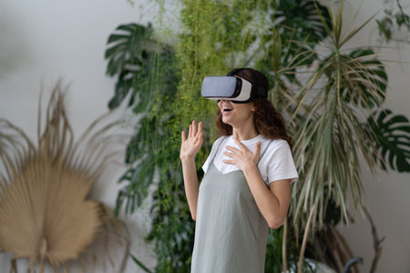 Virtual entertainment at home garden. Overjoyed woman in VR headset playing interactive video game