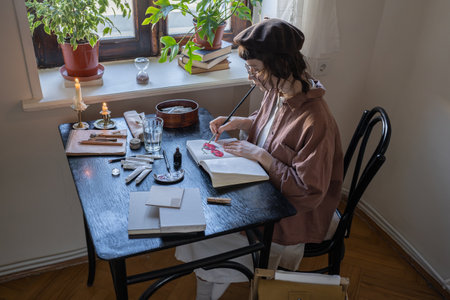 Professional artist drawing colorful picture in cozy studio, workshop at table with artist tools