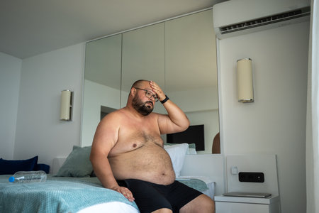 Heavy man suffers from excessive sweating abnormal heat and high unbearable temperature sweats lotの写真素材