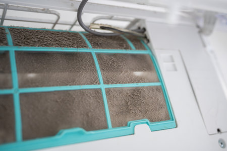 Closeup of dirty dust air conditioner filter on wall. Home air conditioner maintenanceの写真素材