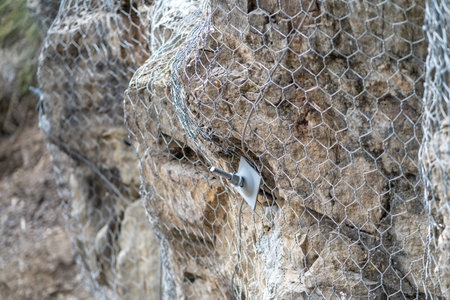 Landslide and rock sliding prevention in Turkey, reinforcing mountain slope with metal mesh.