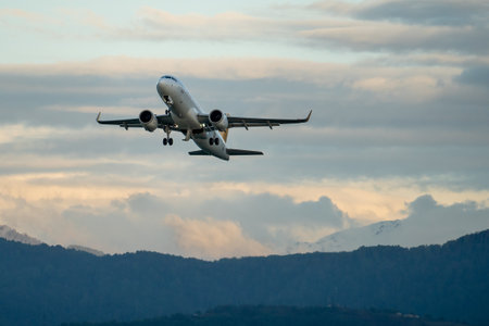 Airplane taking off from the airport, mountain on background.