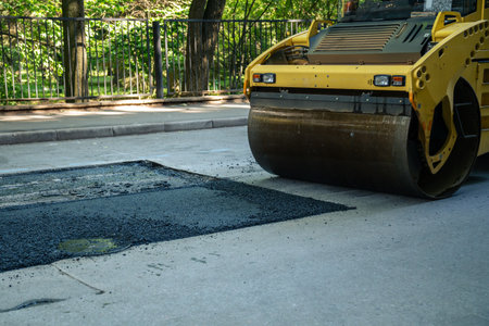 Roller for laying fresh hot asphalt on the road. Road construction equipment.