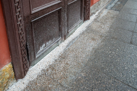 Thaw salt covering sidewalk near building entrance for deicing, surface frost removal in winterの写真素材