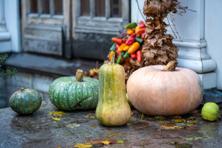 Autumn style photo background with pumpkin yellow leaves sweet peppers on street in rainy weather.