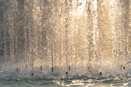 Close up of splash of water in fountain at sunset..の写真素材